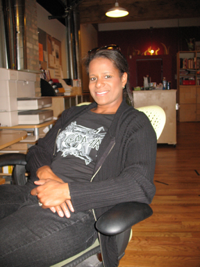 Debi Thomas sitting and smiling in a photo for the Manleywoman Skatecast, a figure skating podcast